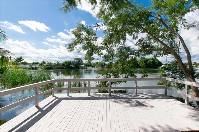 a view of a lake with a bench next to a yard