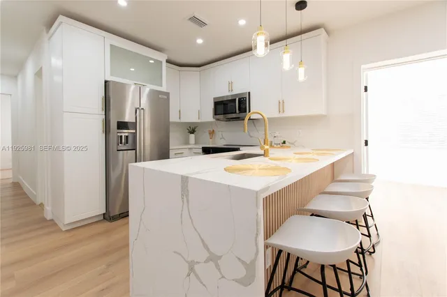 a kitchen with stainless steel appliances a sink and a refrigerator