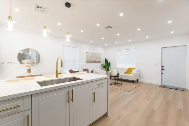 a kitchen with sink and mirror