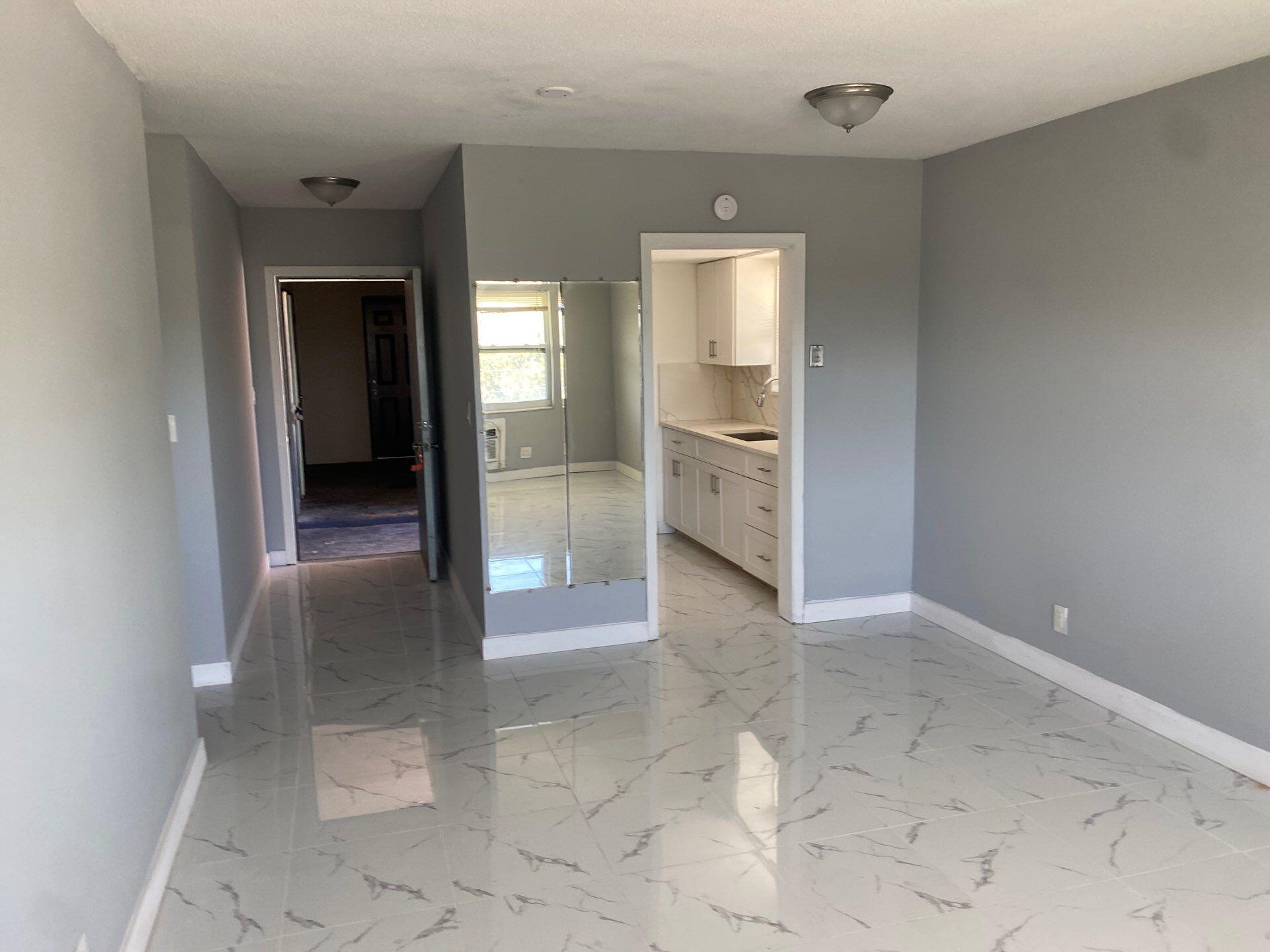 1150 East Sample Road, Unit 302 Pompano Beach, FL 33064 - Photo 3 of 3 an empty room with mirror