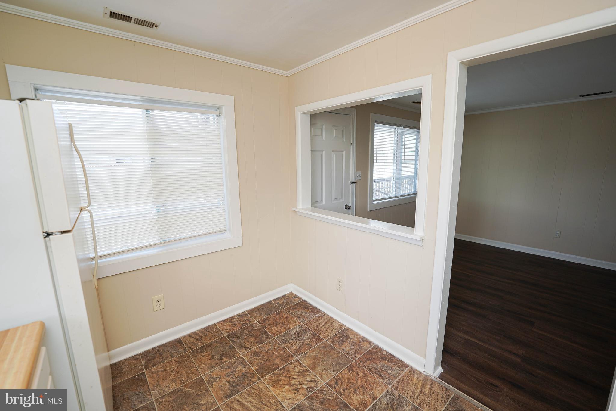 516 Bay Street, Unit D4 Berlin, MD 21811 - Photo 13 of 27 a view of an empty room with wooden floor and a window