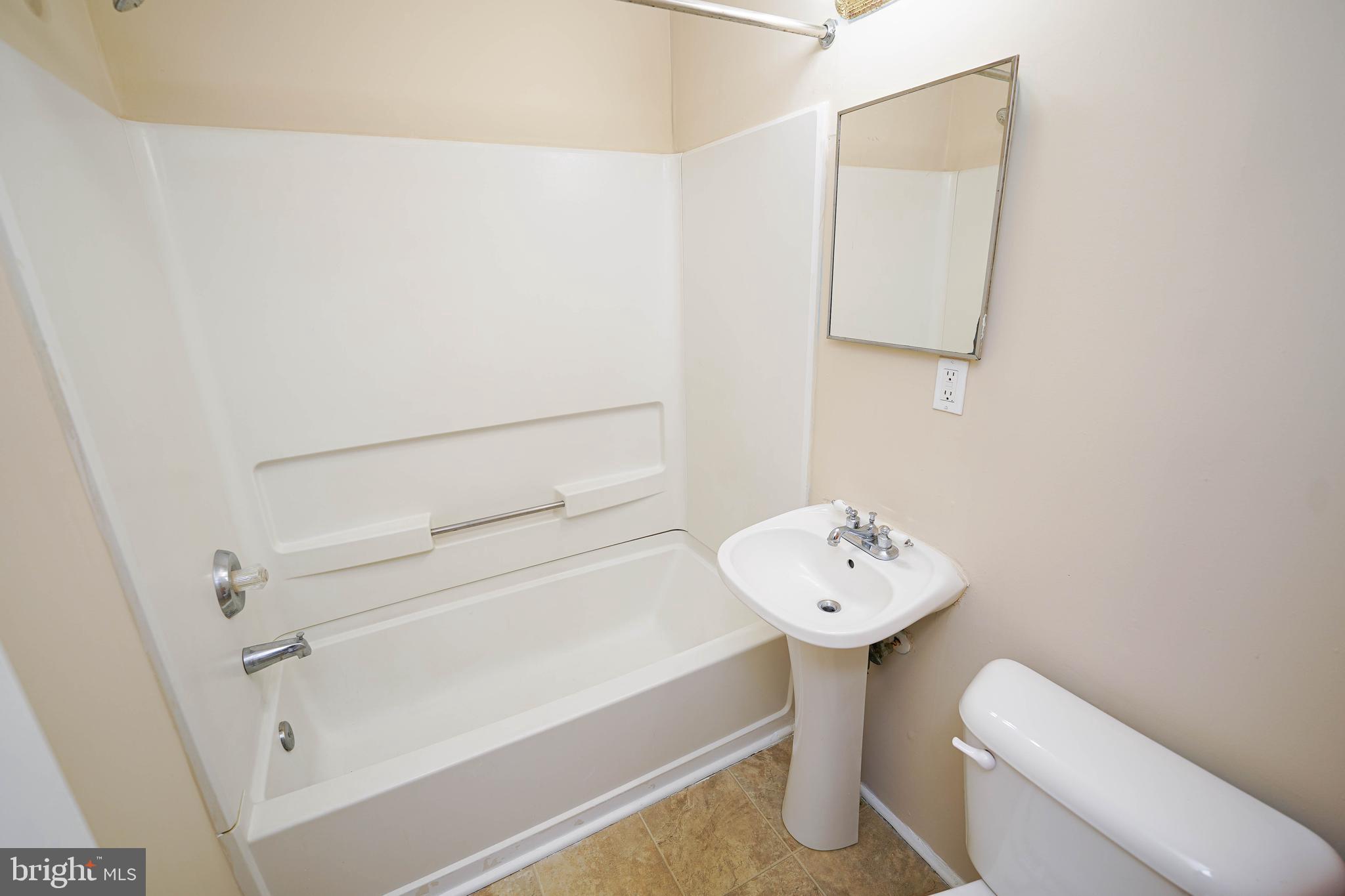 516 Bay Street, Unit D4 Berlin, MD 21811 - Photo 21 of 27 a bathroom with a sink a mirror and a toilet