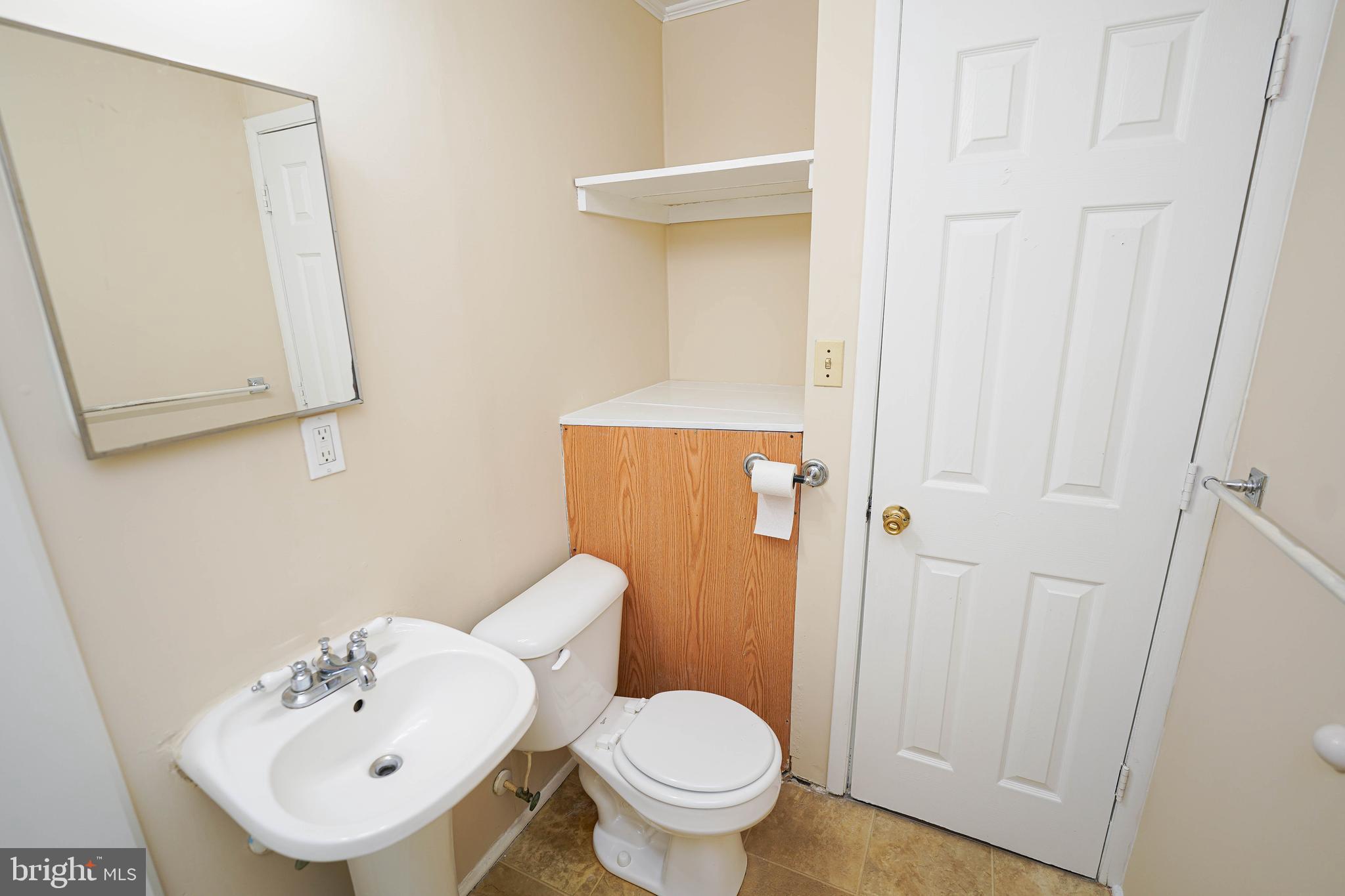516 Bay Street, Unit D4 Berlin, MD 21811 - Photo 22 of 27 a bathroom with a toilet a sink and mirror