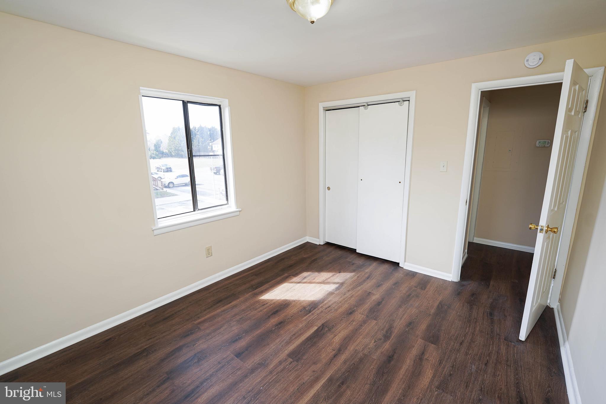 516 Bay Street, Unit D4 Berlin, MD 21811 - Photo 26 of 27 an empty room with wooden floor and windows