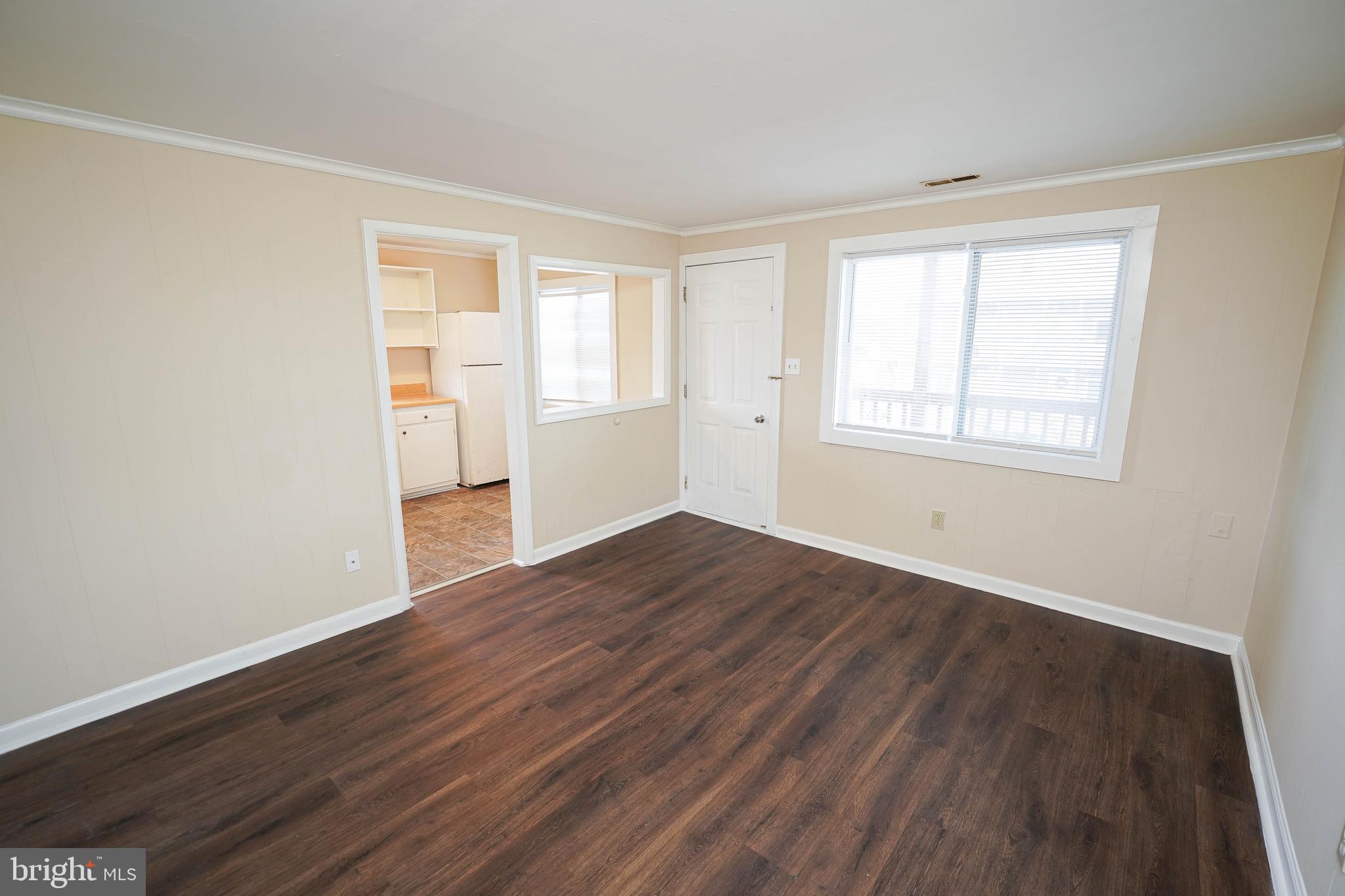 516 Bay Street, Unit D4 Berlin, MD 21811 - Photo 6 of 27 an empty room with wooden floor and windows