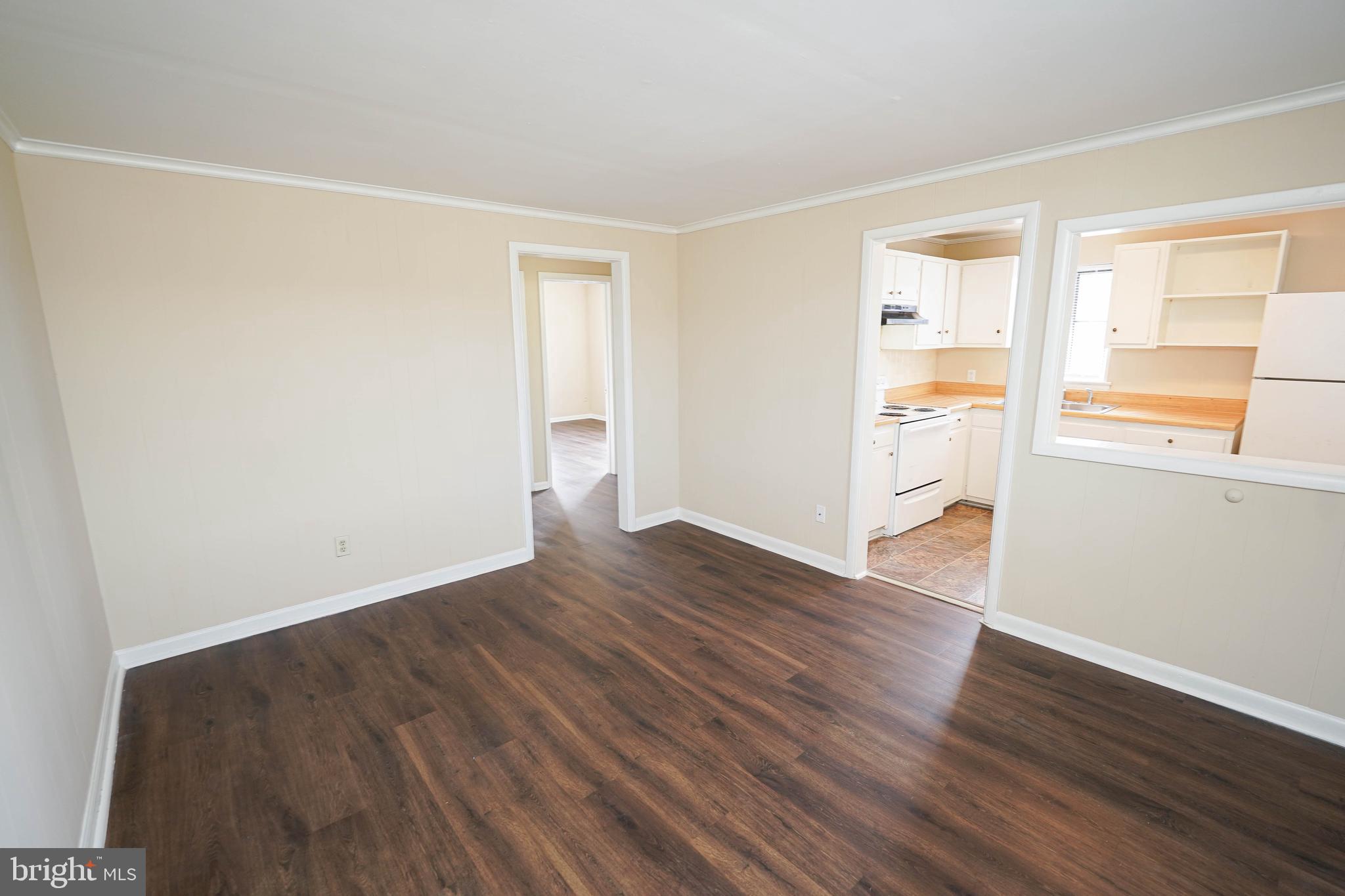 516 Bay Street, Unit D4 Berlin, MD 21811 - Photo 7 of 27 a view of an empty room with wooden floor and a window