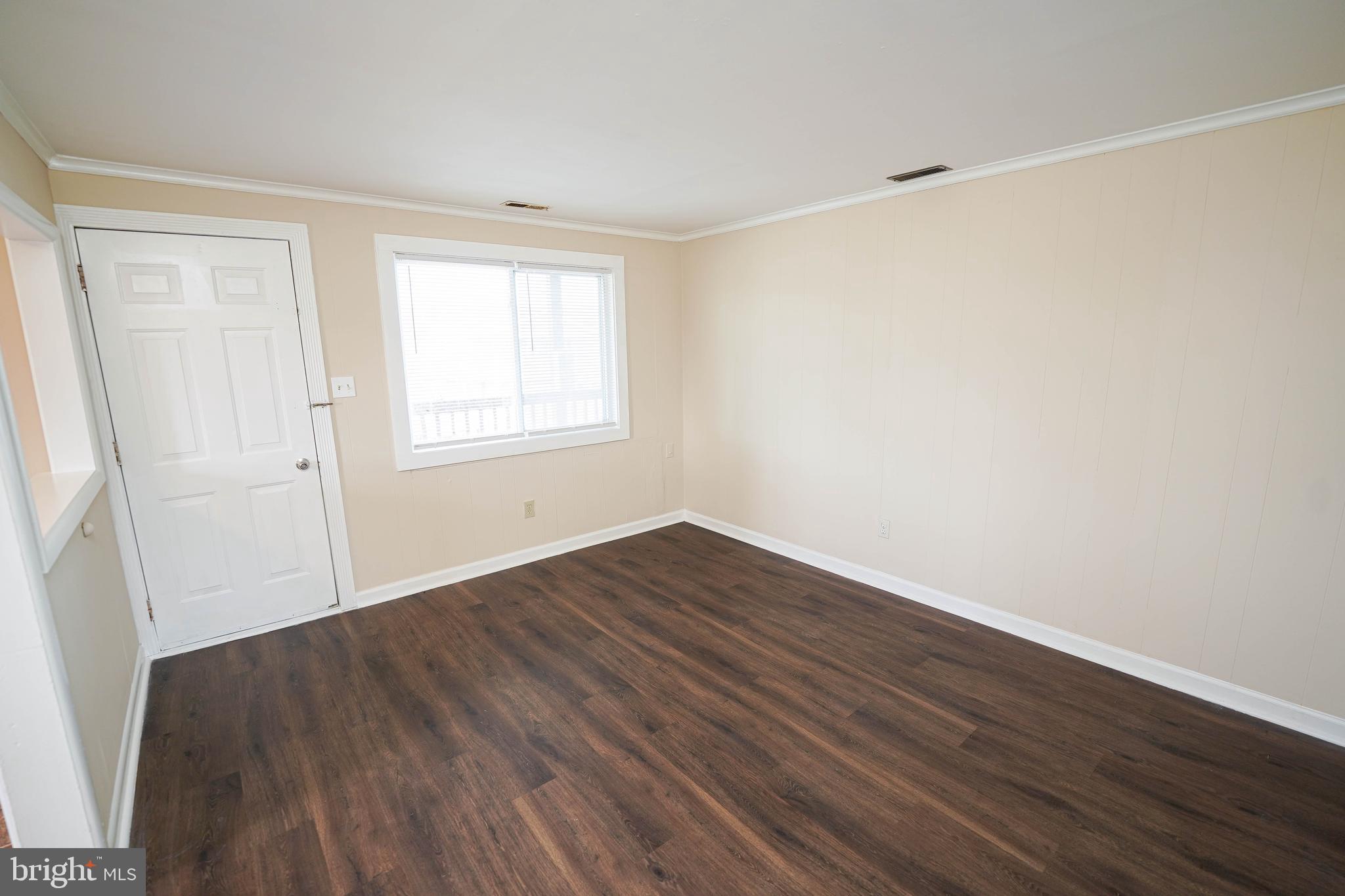 516 Bay Street, Unit D4 Berlin, MD 21811 - Photo 9 of 27 an empty room with wooden floor and windows