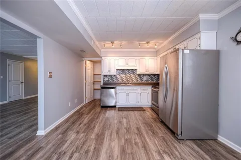a kitchen with stainless steel appliances granite countertop a refrigerator and a stove top oven