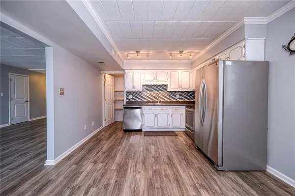 a kitchen with stainless steel appliances granite countertop a refrigerator and a stove top oven