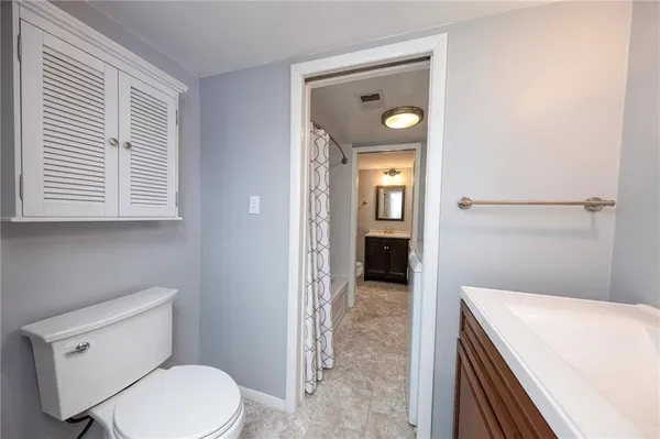 a bathroom with a toilet a sink and mirror