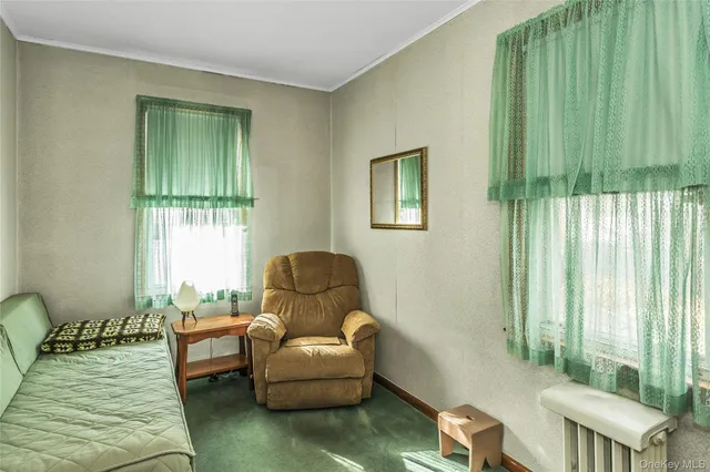 a living room with a flat screen tv and a refrigerator