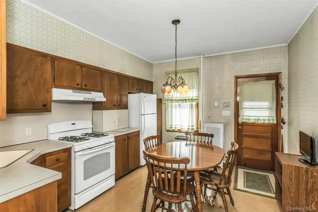 a kitchen that has a stove a table and chairs in it
