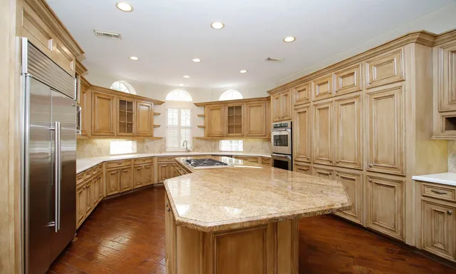 a kitchen with stainless steel appliances granite countertop a refrigerator and a sink
