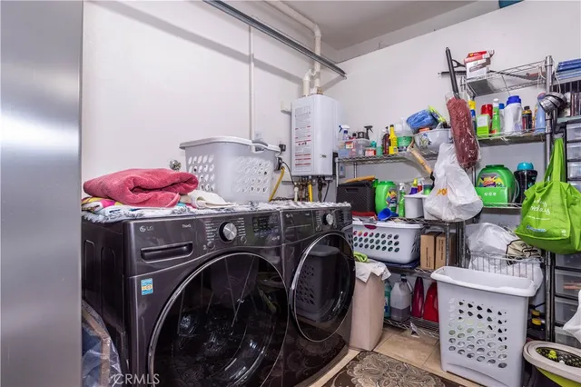 a utility room with dryer washer and a view of living room