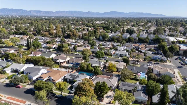 an aerial view of a city with lots of residential buildings and mountain view in back