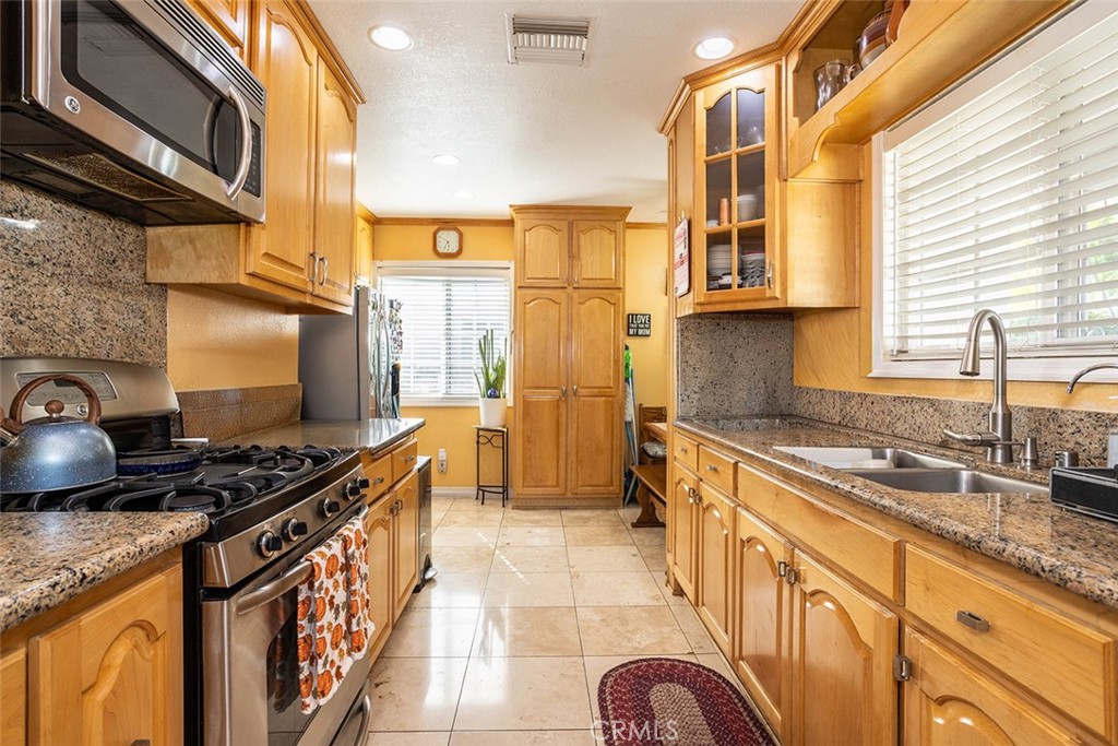 7414 Quartz Avenue Winnetka, CA 91306 - Photo 7 of 42 a kitchen with stainless steel appliances granite countertop a stove a sink and a microwave