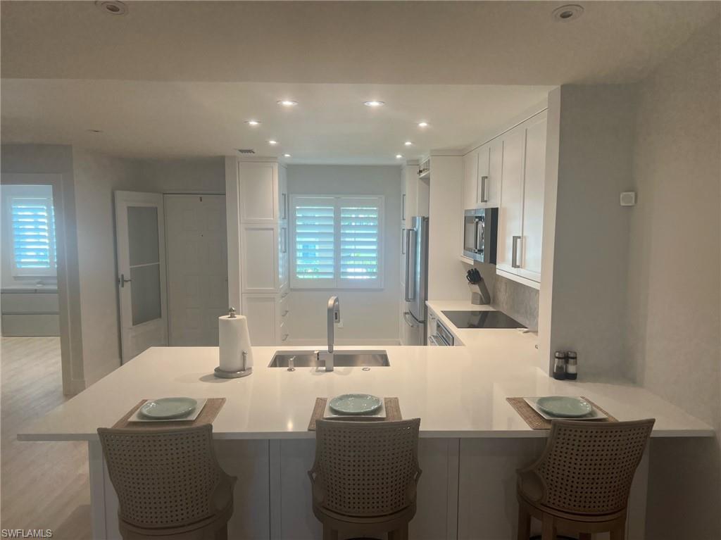 7713 Jewel Lane, Unit 202 Naples, FL 34109 - Photo 11 of 25 a bathroom with a sink and a mirror