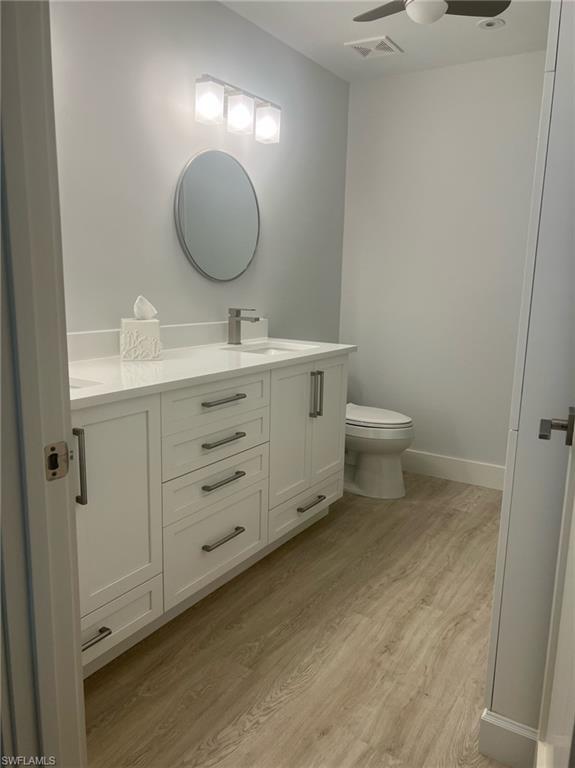 7713 Jewel Lane, Unit 202 Naples, FL 34109 - Photo 20 of 25 a bathroom with a toilet sink and mirror