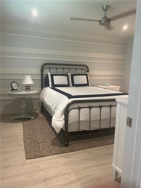 7713 Jewel Lane, Unit 202 Naples, FL 34109 - Photo 23 of 25 a bedroom with a bed and a machine with wooden floor