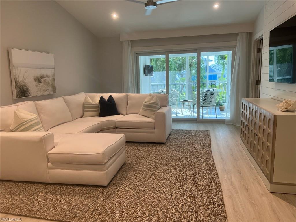 7713 Jewel Lane, Unit 202 Naples, FL 34109 - Photo 2 of 25 a living room with furniture and a flat screen tv