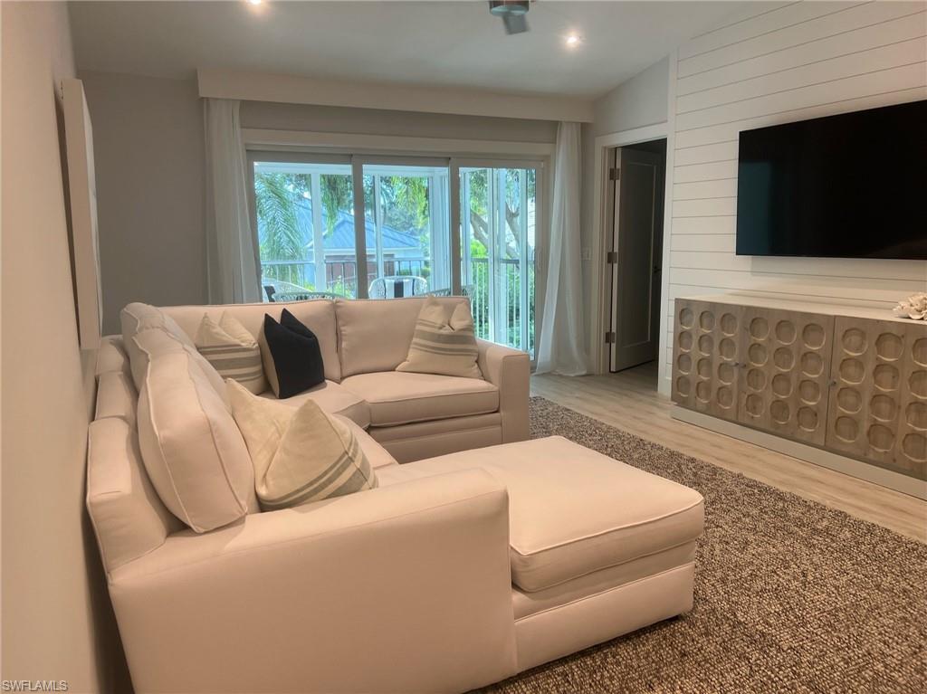 7713 Jewel Lane, Unit 202 Naples, FL 34109 - Photo 3 of 25 a living room with furniture and a flat screen tv