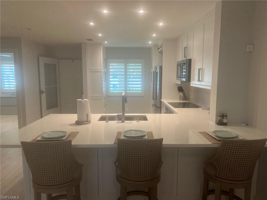 7713 Jewel Lane, Unit 202 Naples, FL 34109 - Photo 6 of 25 a dining room with a granite countertop furniture and a window