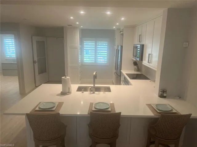 a living room with furniture large windows and wooden floor