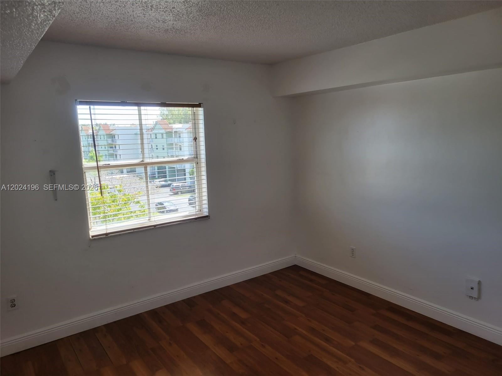 8260 Southwest 210th Street, Unit 319 Cutler Bay, FL 33189 - Photo 8 of 20 an empty room with wooden floor and windows