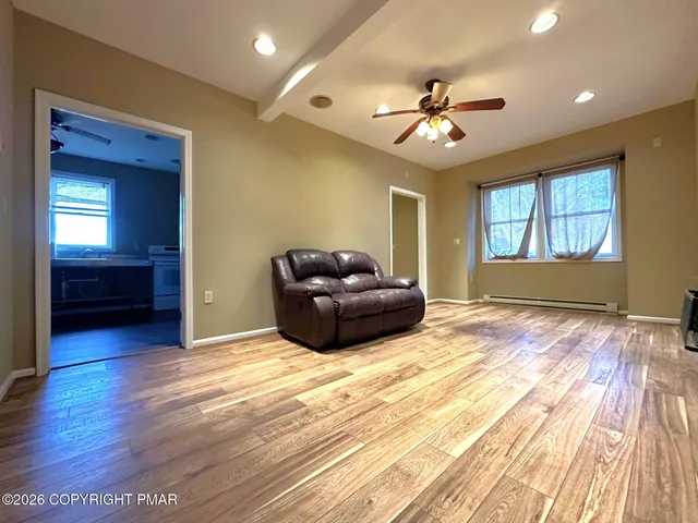 a living room with furniture and a ceiling fan