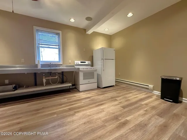 a view of a kitchen with a stove wooden cabinets and a refrigerator