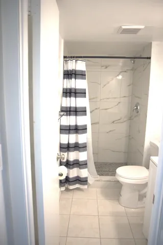 a white toilet sitting next to a sink and a mirror