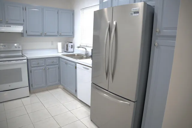 a kitchen with a refrigerator sink and cabinets