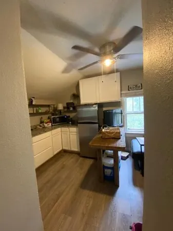 a kitchen with cabinets and wooden floor
