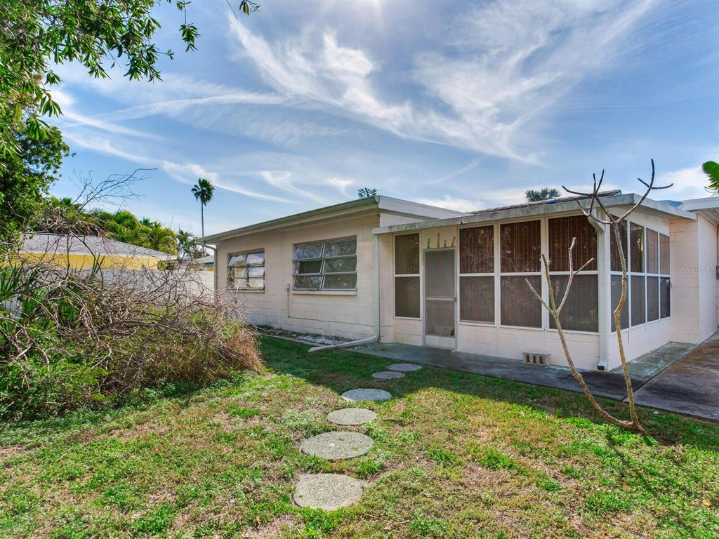 16105 1st Street East Redington Beach, FL 33708 - Photo 14 of 27 a view of a backyard with potted plants and large tree
