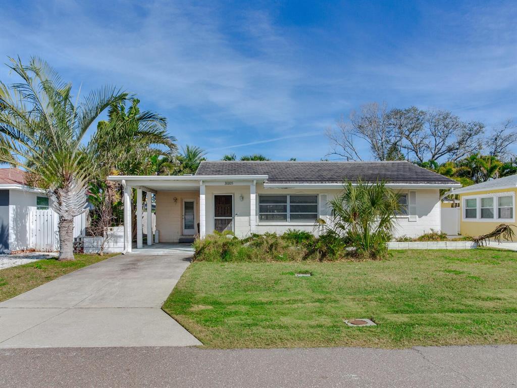 16105 1st Street East Redington Beach, FL 33708 - Photo 9 of 27 a front view of a house with a garden and trees