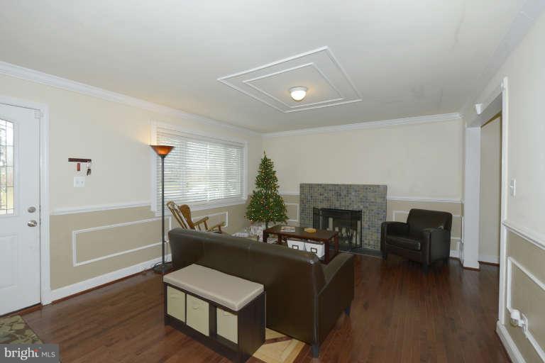 6023 Craig Street Springfield, VA 22150 - Photo 2 of 27 a living room with furniture and a fireplace