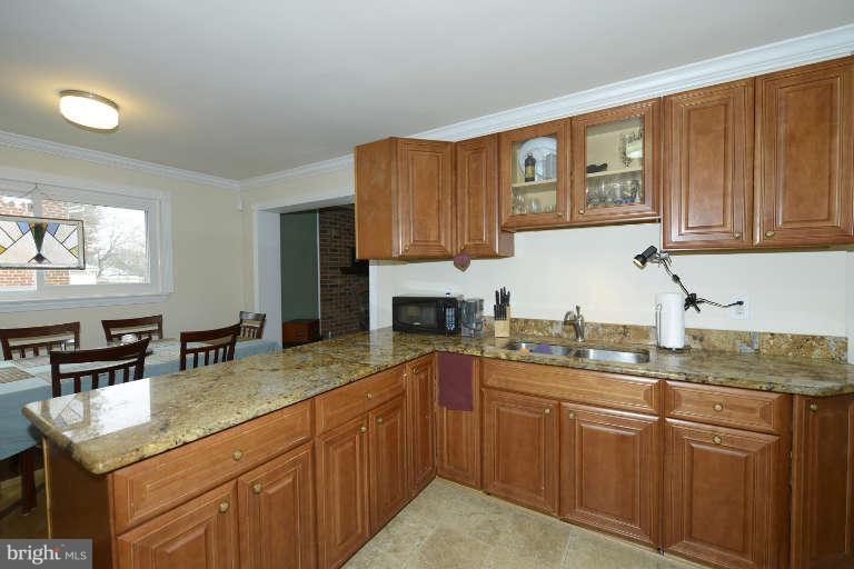 6023 Craig Street Springfield, VA 22150 - Photo 11 of 27 a kitchen with kitchen island granite countertop a sink cabinets and window