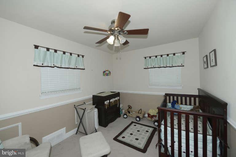 6023 Craig Street Springfield, VA 22150 - Photo 14 of 27 a bedroom with a bed and wooden floor