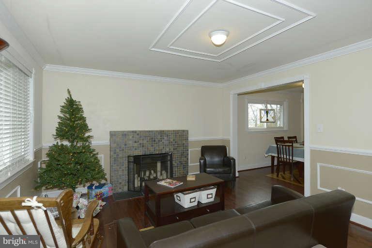 6023 Craig Street Springfield, VA 22150 - Photo 3 of 27 a living room with furniture a fireplace and a flat screen tv