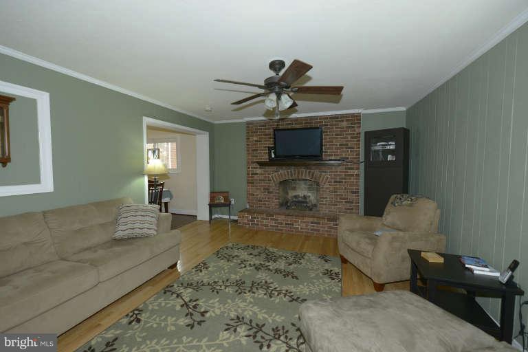 6023 Craig Street Springfield, VA 22150 - Photo 5 of 27 a living room with furniture a flat screen tv and a fireplace