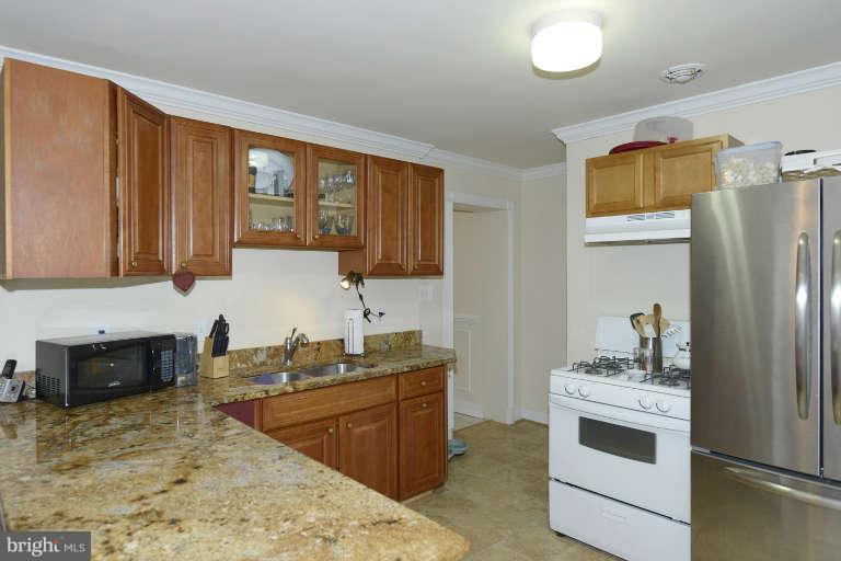 6023 Craig Street Springfield, VA 22150 - Photo 9 of 27 a kitchen with stainless steel appliances granite countertop a sink stove and refrigerator