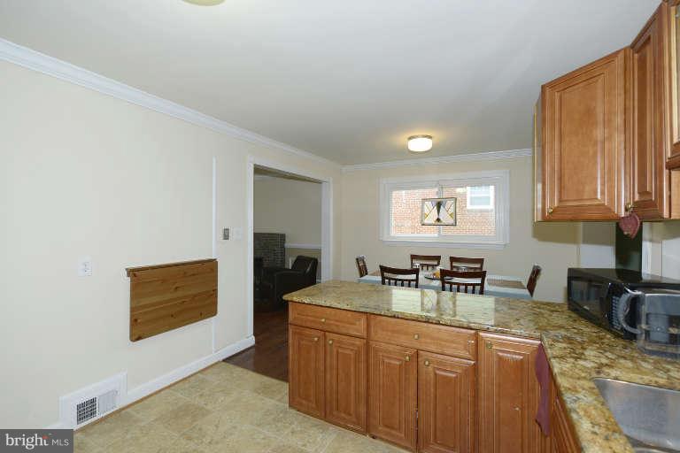 6023 Craig Street Springfield, VA 22150 - Photo 10 of 27 a kitchen with sink cabinets and dining table