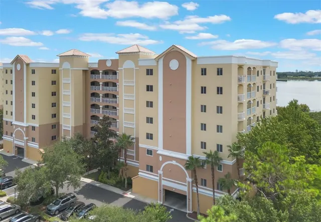 a front view of a building with glass windows and plants