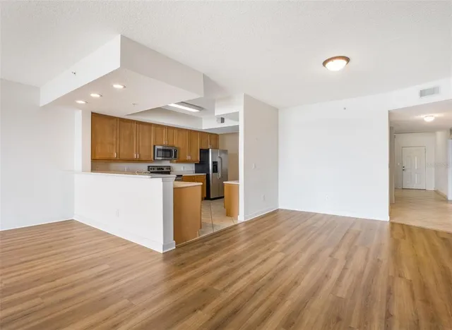 a view of empty room with wooden floor and window