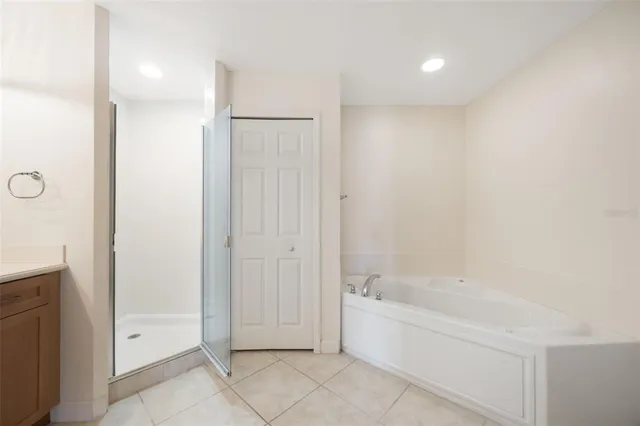 an empty room with wooden floor and fan