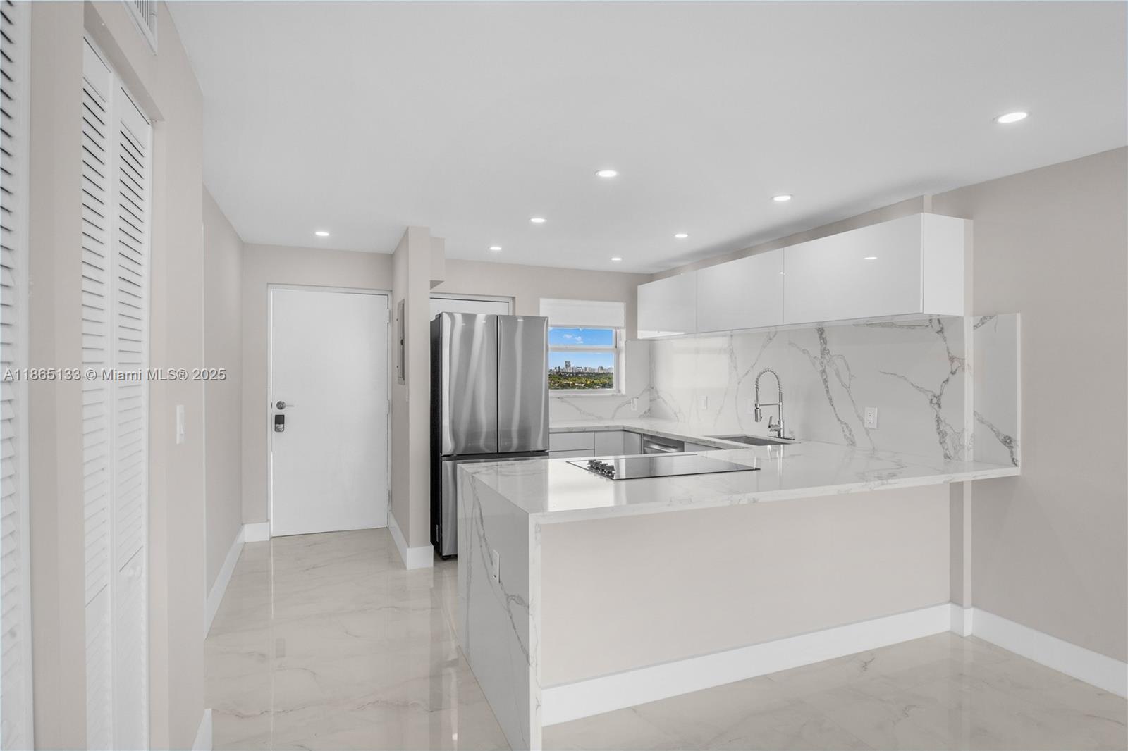 1331 Lincoln Road, Unit 1302 Miami Beach, FL 33139 - Photo 2 of 40 a kitchen with stainless steel appliances a refrigerator and a stove top oven