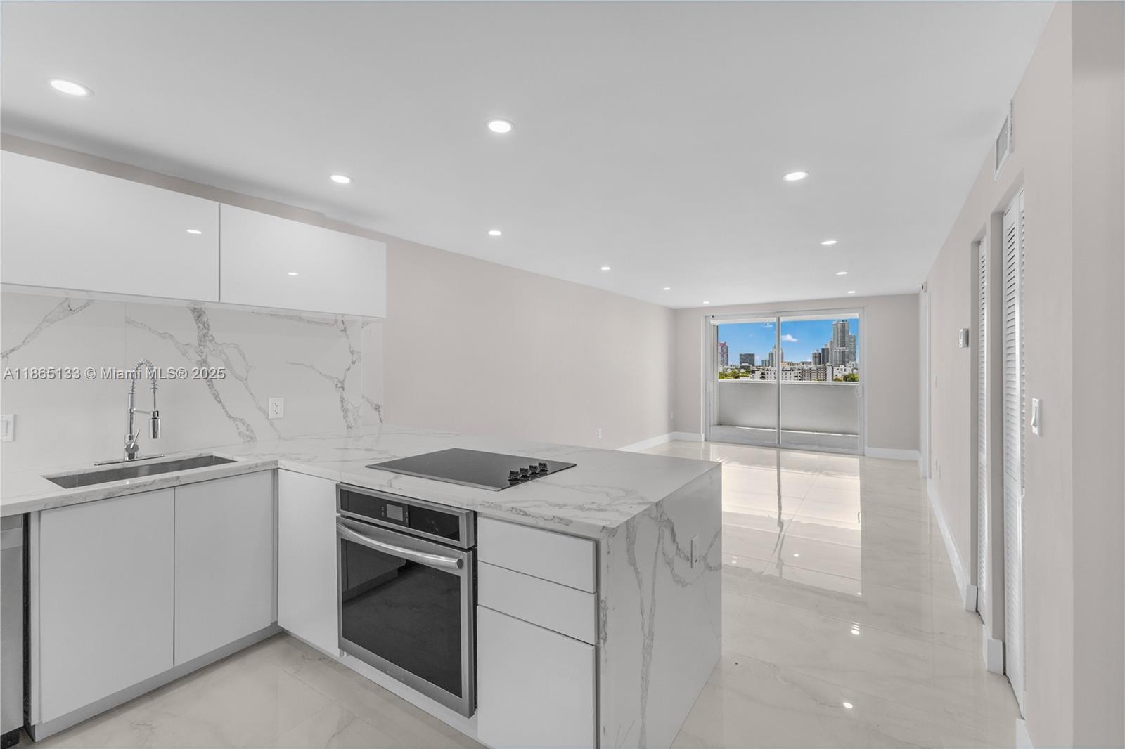 1331 Lincoln Road, Unit 1302 Miami Beach, FL 33139 - Photo 3 of 40 a kitchen that has a sink and a stove in it