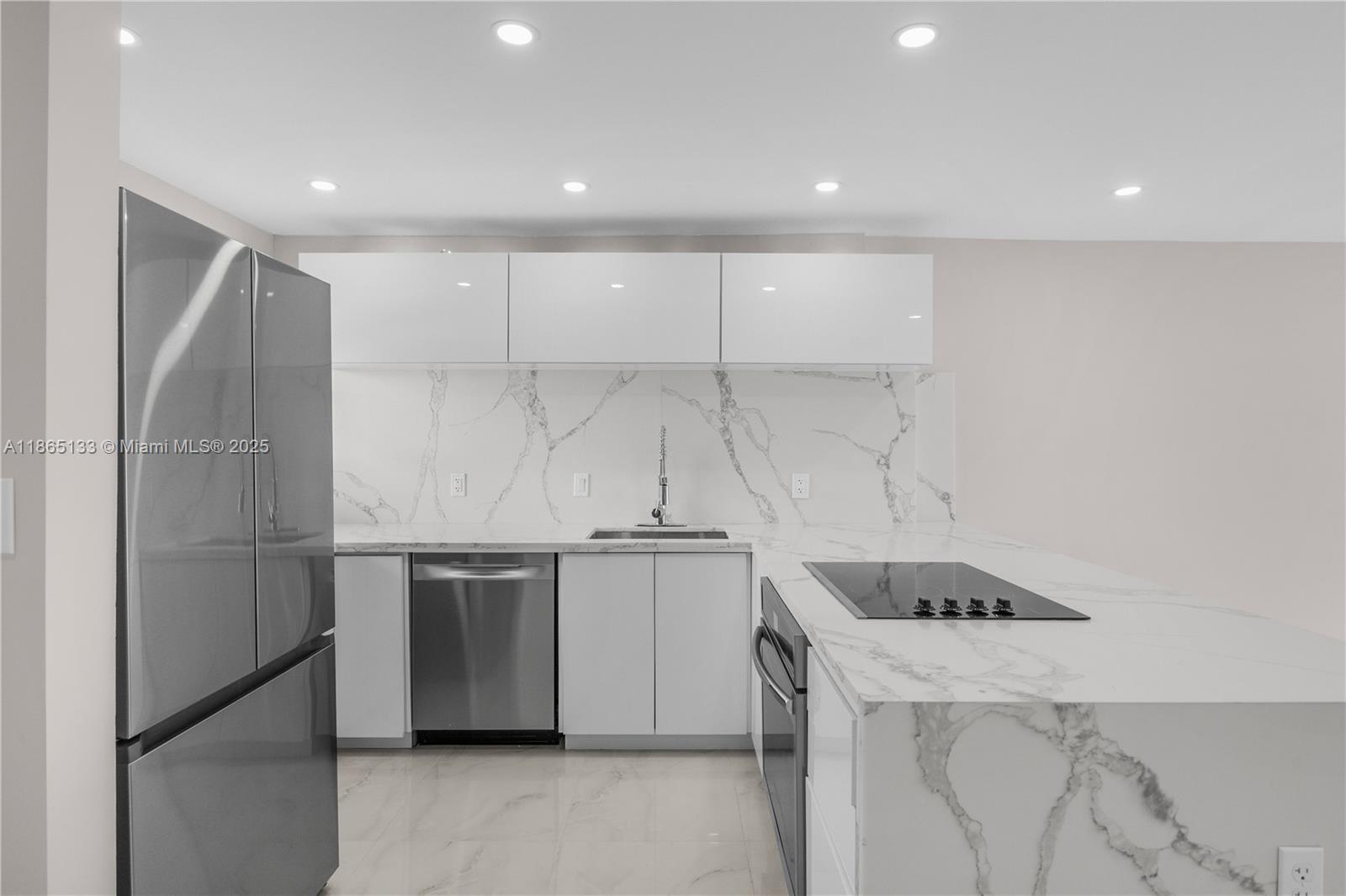 1331 Lincoln Road, Unit 1302 Miami Beach, FL 33139 - Photo 5 of 40 a kitchen with kitchen island a counter top space and stainless steel appliances
