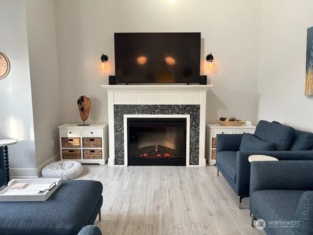 a living room with furniture a flat screen tv and a fireplace