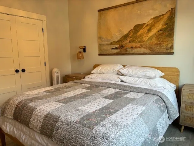 a bedroom with a bed and a painting on the wall